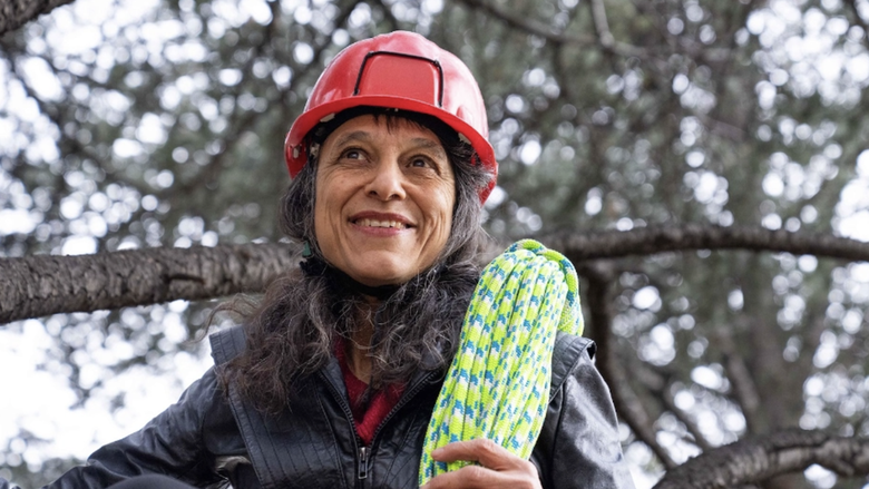 Ecologist Nalini Nadkarni wears a helmet and holds a rope for climbing trees and exploring tree ecology