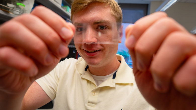 man holding thin film in front of his face