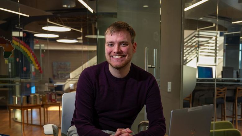 Master of AI student Nicholas Gahman sits at a desk in front of a laptop in Penn State Great Valley's Technology Commons.