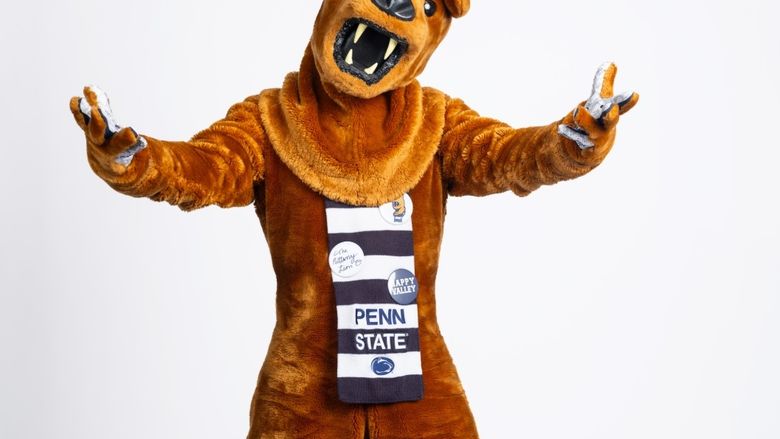 The Nittany Lion mascot extends both arms while facing the camera