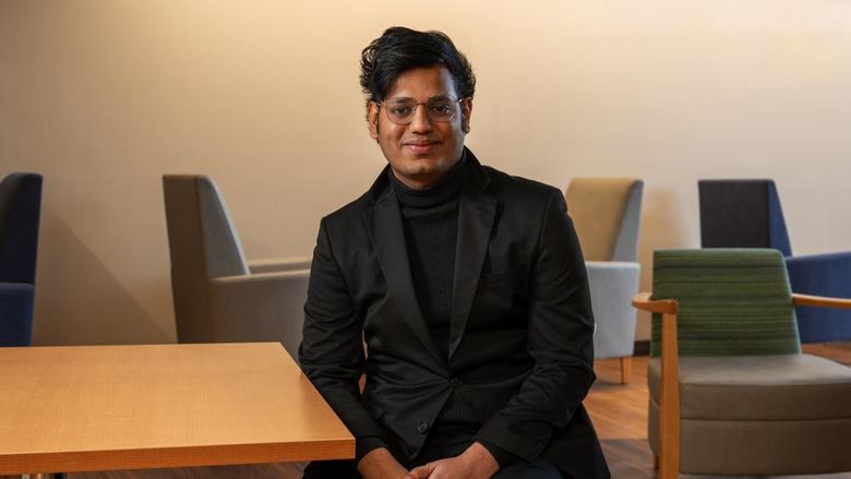 Data analytics graduate Rahul Vemuri sits at a table on Penn State Great Valley's campus