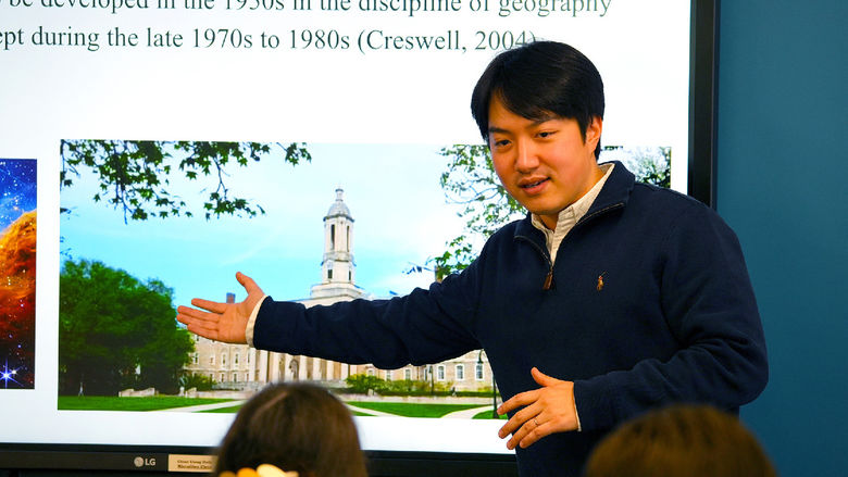 person pointing to projector screen while giving a lecture