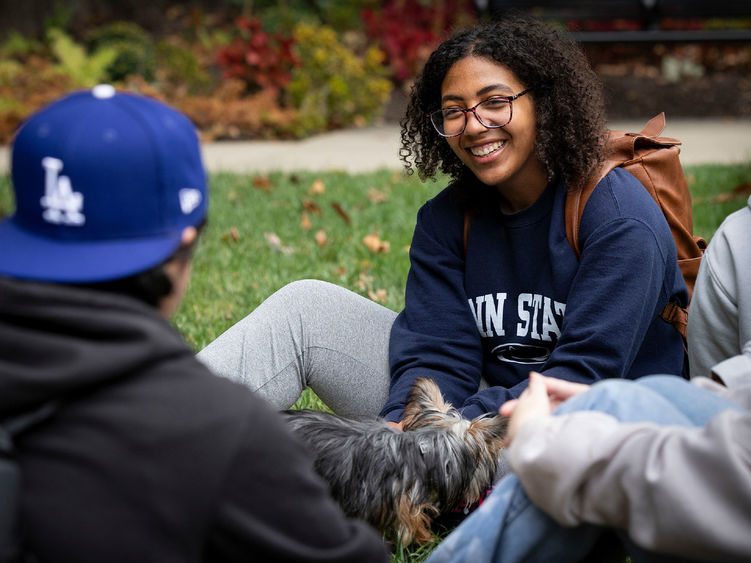 Woman in Penn State sweatshirt talking to other students