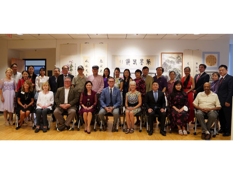 Large group of people sitting and standing in front of an art display