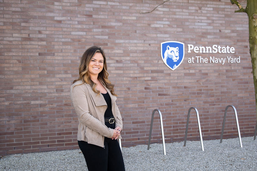 Alexis Doherty standing in front of a wall with the Penn State at the Navy Yard logo