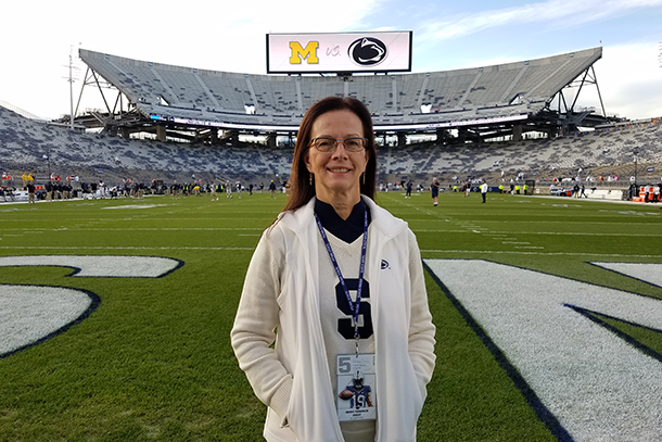 Woman wearing white stands on a football field. 