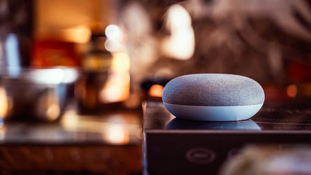 A Google Home smart device sits on a surface.