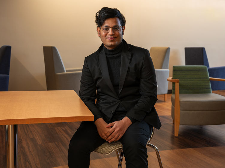 Data analytics graduate Rahul Vemuri sits at a table on Penn State Great Valley's campus