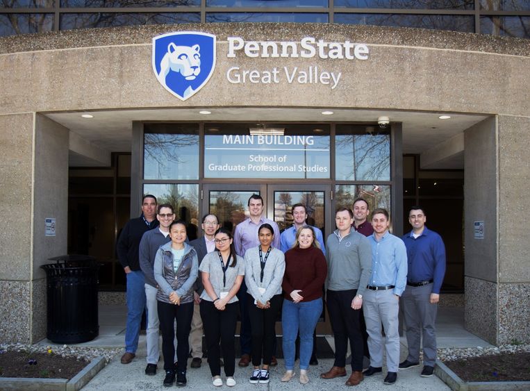 A group of graduate finance students in front of Penn State Great Valley's Main Building